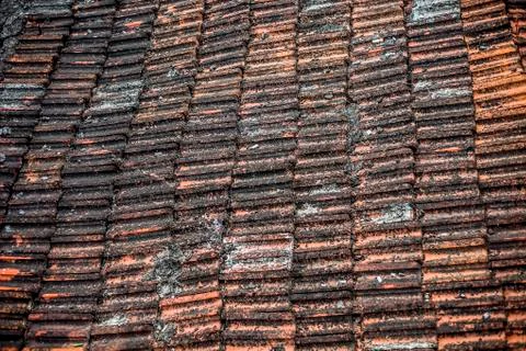 Top shot of the old-styled rectangular-shaped rooftop tiles fixed on a roof o Stock Photos