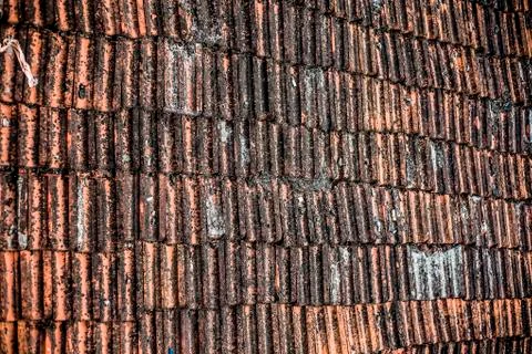 Top shot of the old-styled rectangular-shaped rooftop tiles fixed on a roof o Stock Photos