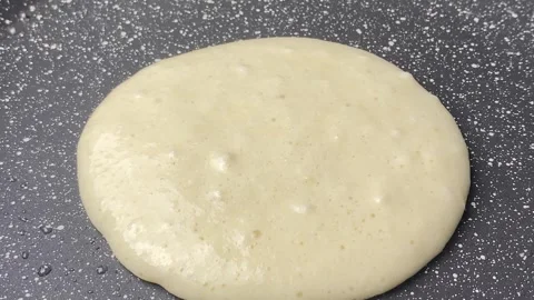 Top shot pancake cooking process in a frying pan. Close up shot of spatula Stock Footage 240661181