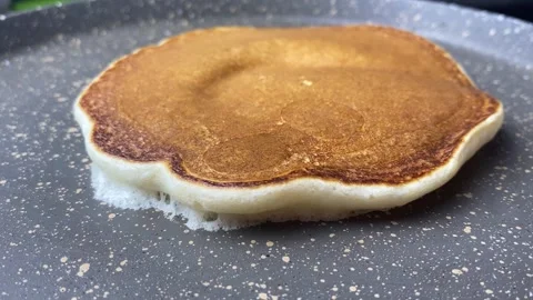 Top shot pancake cooking process in a frying pan. Close up shot of spatula Stock Footage 240661325