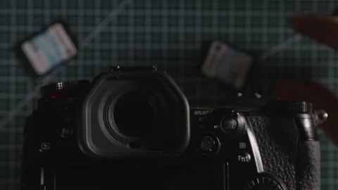 Top shot of professional camera with multiple SD cards on workbench Stock Footage 333763918