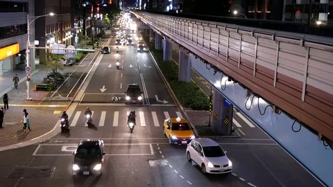 Top shot of skytrain passing by building and heavy traffic flow at night Video stock 82774063