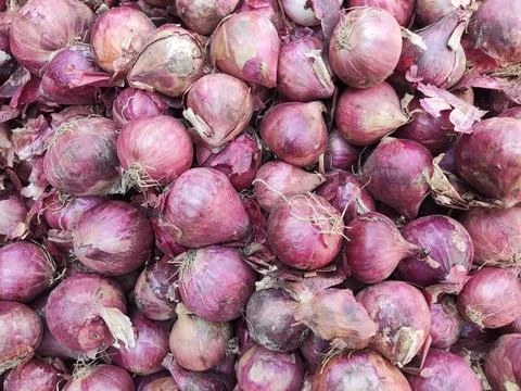 Top shot of a stack of local red onions for sale in a vegetable market Stock Photos