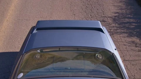 Top shot of the trunk of an old car driving on a country road, in Spain Stock Footage 208813549