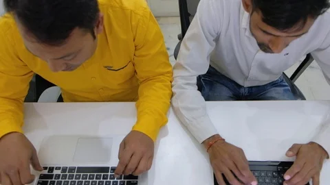 Top shot of two colleagues typing fast for urgent work for delivery on the keybo Stock Footage 100026673