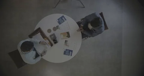 Top Shot of two men sitting on a table - Shot on RED 5K Stock-Footage 113604773