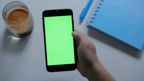 Top Shot-Using an application with tapping.Smartphone green screen on desk Stock-Footage 123079271