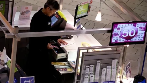 Top shot of worker counting lottery ticket inside mall lottery ticket retailer Stock Footage 73312454