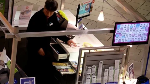 Top shot of worker counting lottery ticket inside mall lottery ticket retailer Video stock 73342103
