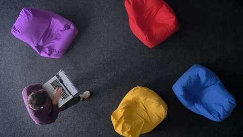 Top-shot of young man walking and working with laptop on multicoloured bags Video stock 99781616