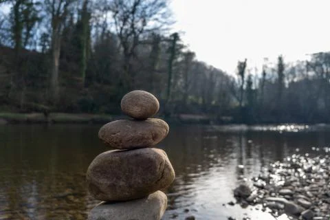 The top of a stack of balancing stones with a river in the background Stock Photos