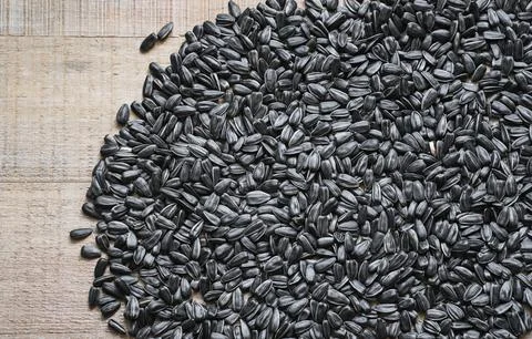 Top table view on not peeled sunflower seed at wooden background. Stock Photos