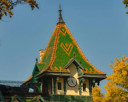 Top of tower like building with clock and green and orange square roof Stock Photos