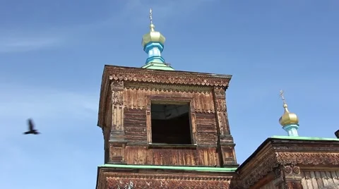 Top of tower with a dome of wooden church in Karakol, black bird flying Video stock 59573664