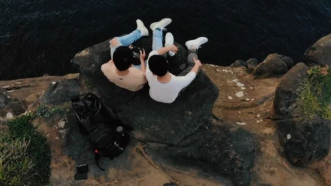 Top view of 2 friends sitting on the elephant trunk cliff in a beautiful morning Stock Footage 103361835
