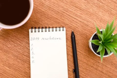 Top view 2019 resolutions list with notebook, cup of coffee on wooden desk Stock Photos