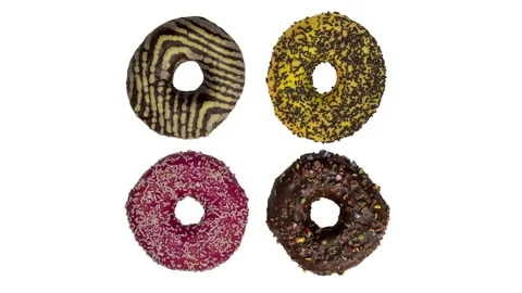 Top view of 4 different donuts - brown, yellow, red, chocolate, sprinkles, st Stock Footage 150986614