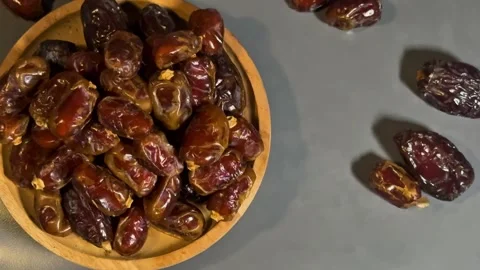 Top View 4K Footage of Dried Dates in Wooden Bowl on Gray Background Stock Footage 328136948