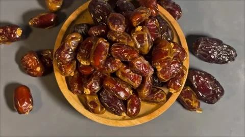 Top View 4K Footage of Dried Dates in Wooden Bowl on Gray Background Stock Footage 328136962