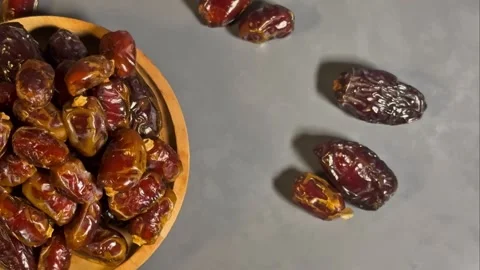 Top View 4K Footage of Dried Dates in Wooden Bowl on Gray Background Stock Footage 328136967