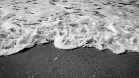 Top view 4K resolution video banner with sand, sea foam and waves toned in gray Stock Footage 239280479
