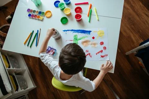 Top View of 5 Year Old Left Handed Boy Cleaning Paintbrush from Paint. Stock Photos