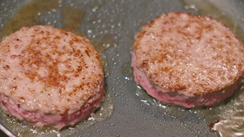 Top View of Aberdeen Angus Beef Burgers Cooking with Oil Spitting Up in Slow Stock Footage 320999172