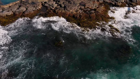 Top View from above. Ocean waves roll on the rocky shore. Stock Footage 129393289