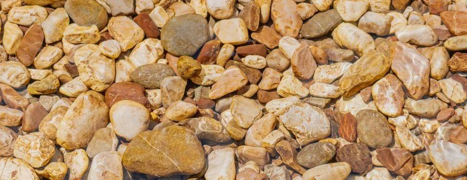 Top view abstract background of smooth river stones and pebbles under clear.. Stock Photos