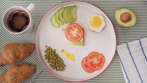 Top view accelerated shooting women's hands cut toast with avocado and egg. Fast Stock Footage 138080146
