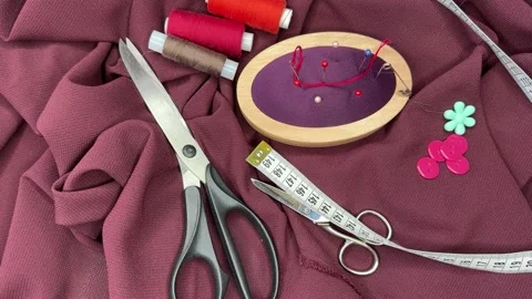 Top view of accessories for cutting and sewing a burgundy silk dress Stock Footage 306561095