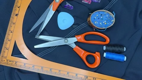 Top view of accessories for cutting and sewing a blue silk dress Stock Footage 306561096