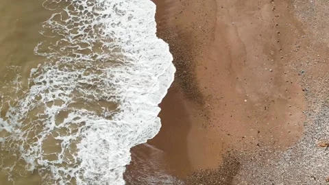 Top view of aerial drone footage of waves crushing into coastline. Stock Footage