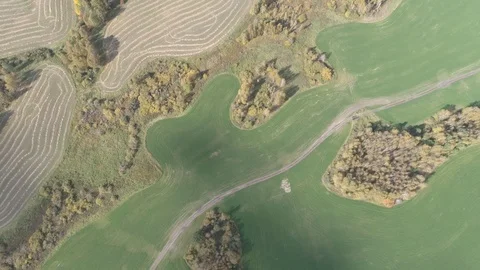 Top view aerial fly over a mowed field with small Islands of forest and road Stock Footage 115910707