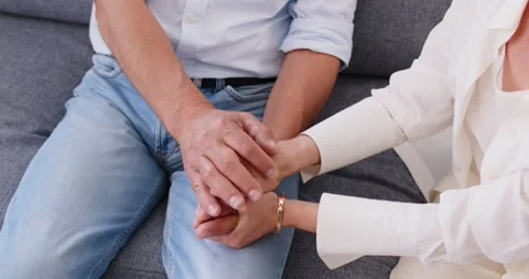 Top view of affectionate senior elderly couple holding hands sitting on sofa at Stock Footage 311276515