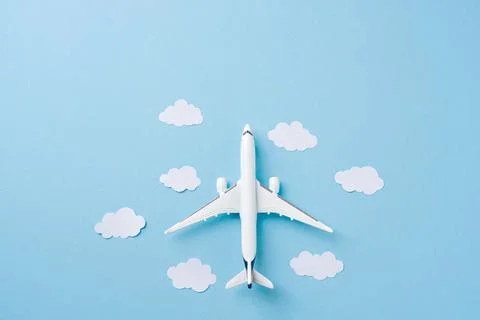 Top view airplane with paper clouds on blue background Stock Photos