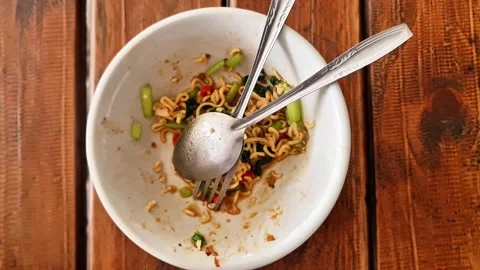 Top view of an almost empty white bowl with leftover spicy instant noodles Stock Footage 347243867