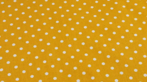 Top view of the amber yellow with white polka dots cotton fabric rotated  Stock-Footage 293884574