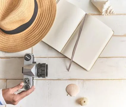 Top view of an analog camera and a notebook on a wooden table, photographer's Stock Photos