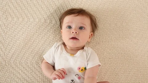 Top view and close-up portrait of cute adorable baby girl wearing white body Stock Footage 93460003