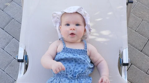Top view and close-up portrait of cute adorable baby girl wearing blue body and Stock Footage 98056278
