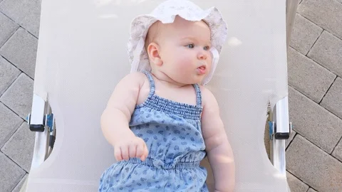Top view and close-up portrait of cute adorable baby girl wearing blue body and Stock Footage 98056531