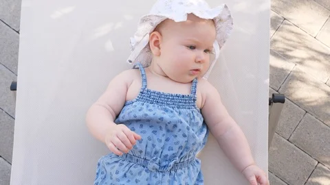 Top view and close-up portrait of cute adorable baby girl wearing blue body and Stock Footage 98056723