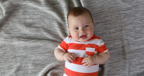 Top view and close-up portrait of cute baby boy in bedroom looking at camera. Se Stock Footage 124659687