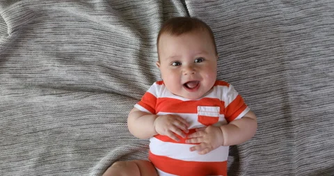Top view and close-up portrait of cute baby boy in bedroom looking at camera. Se Stock Footage 124659998