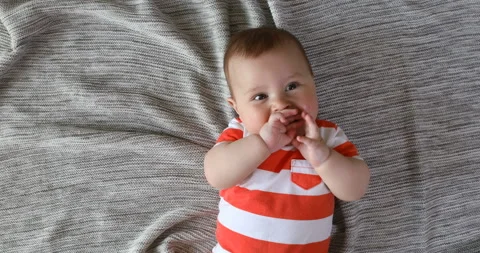 Top view and close-up portrait of cute baby boy in bedroom looking at camera. Se Stock Footage 124661612