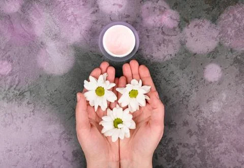 Top view and flat lay of a woman holding a cream in her hands over a blue bac Foto stock