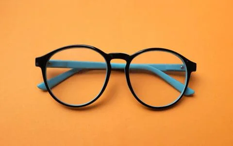 Top view and flat lay round black Eye Glasses isolate on a orange Background Stock Photos