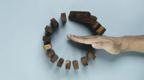 Top view and flat lay design of Businessman use gesture to stop wooden domi.. Stock Photos
