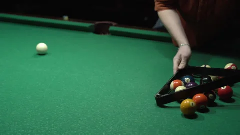 Top view of anonymous man placing colorful pyramid of billiard balls in triangle Stock Footage 256031580